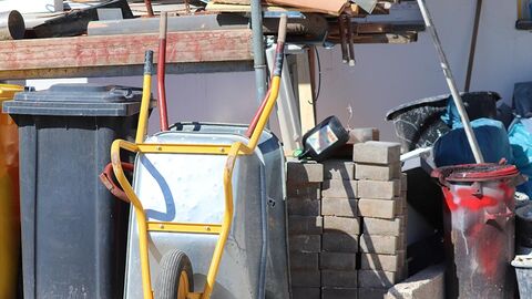 Mülltonne, Schubkarre, Bausteine, Bauabfälle.