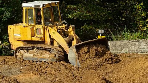 Radlader baggert Erdreich aus.