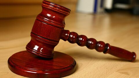 Hölzerner Hammer auf einem Schreibtisch.