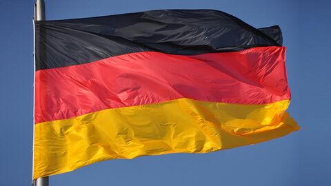 Deutsche Fahne flattert im Wind, im Hintergrund blauer Himmel.