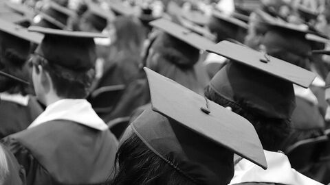 Versammlung von jungen Menschen mit Doktorhüten.