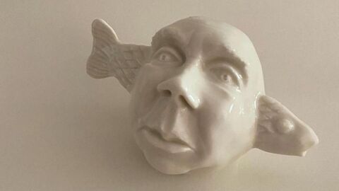 Fischohren Skulptur eines Gesichts mit einem Fisch als Ohren.