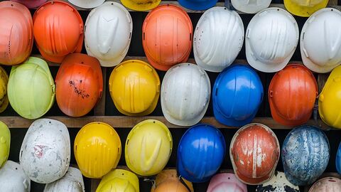 Aufsicht auf viele Bauhelme in verschiedenen Farben.