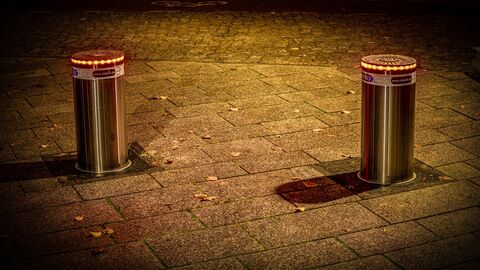 Zwei Poller ragen aus dem Erdreich heraus.